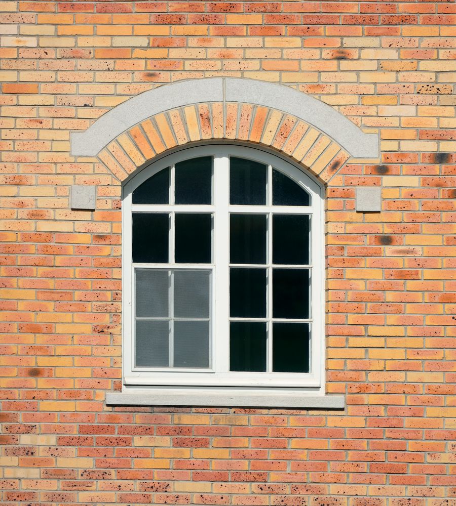 châssis en bois blanc sur mur en briques